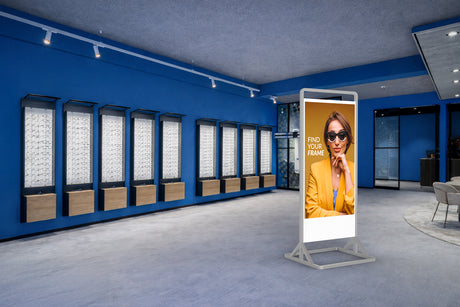 Modern eyewear store interior with digital display and mirror system.