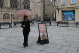 Person holding an umbrella in front of a large building with snow falling